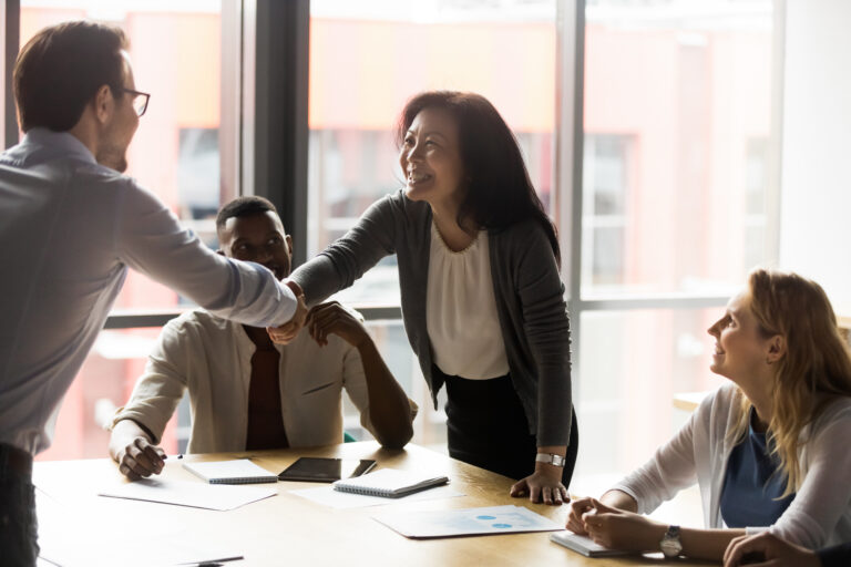 Middle-aged Korean businesswoman shaking hands with young client before a meeting